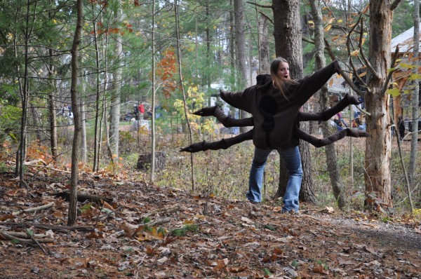 A Penn State student wears a spider costume in the woods